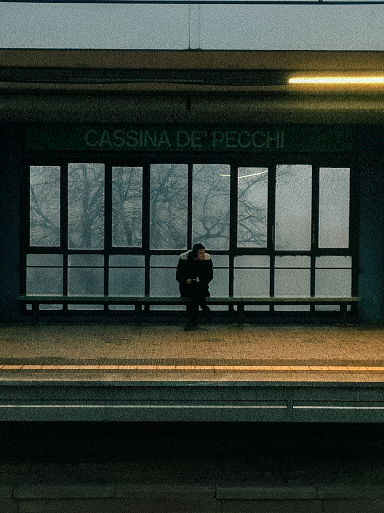 A man waiting in the quiet metro station during the winter.
